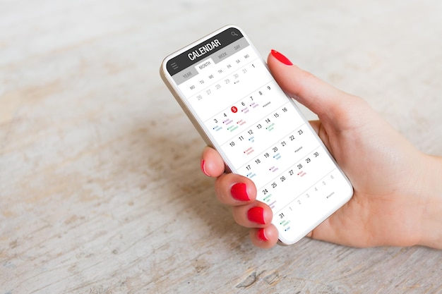 Donna che utilizza l'app del calendario sul telefono cellulare