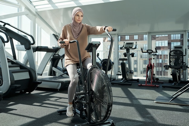 Donna che utilizza la bicicletta stazionaria