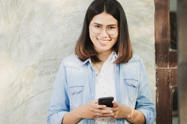 donna che utilizza smartphone che lavora nel tempo libero con felice.