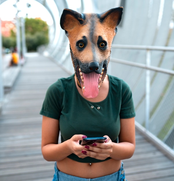 donna che utilizza smartphone, con maschera per cani