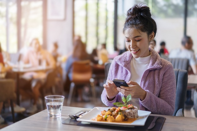 Donna che utilizza smartphone nel ristorante