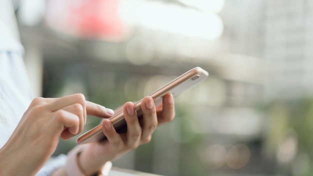 Donna che utilizza smartphone su scala nelle aree pubbliche, durante il tempo libero.