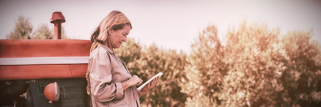 Donna che utilizza tavoletta digitale in fattoria