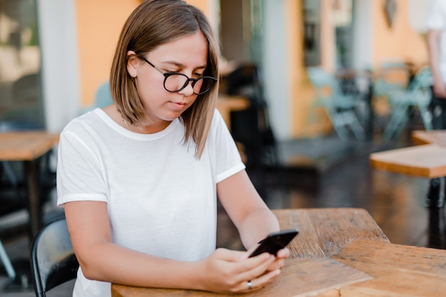 Donna che utilizza telefono nel caffè