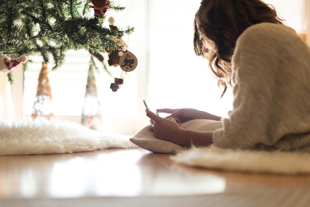Donna che utilizza uno smartphone a casa - Stagione invernale e natalizia