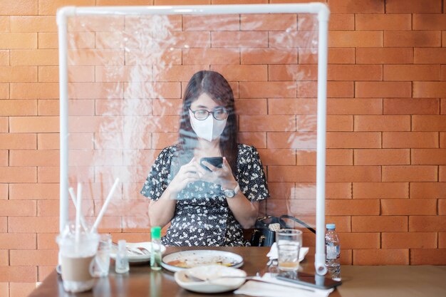 Donna che utilizza uno smartphone nel ristorante
