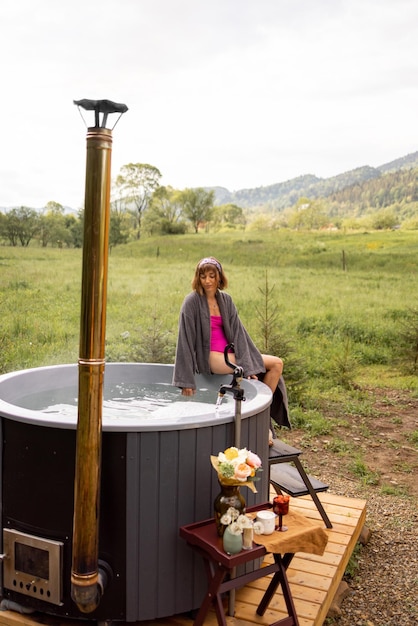 Donna che va a fare il bagno in vasca calda in natura