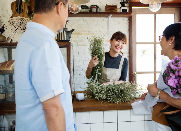 Donna che vende fiori a una coppia