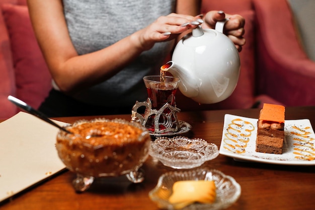 Donna che versa il tè in un caffè