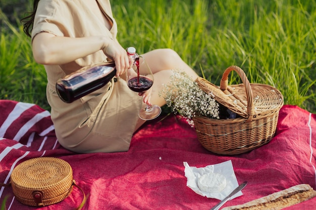 Donna che versa il vino in un bicchiere di vino nel parco