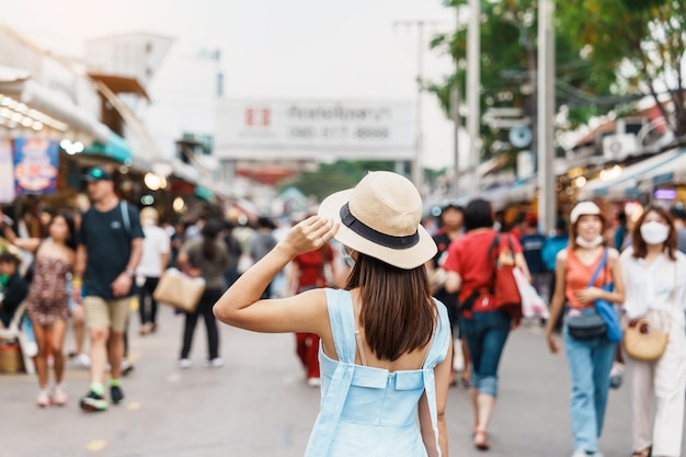 Donna che viaggia con cappello Viaggiatore asiatico in piedi al punto di riferimento del mercato del fine settimana di Chatuchak e popolare per le attrazioni turistiche a Bangkok in Thailandia Viaggio nel concetto di sud-est asiatico