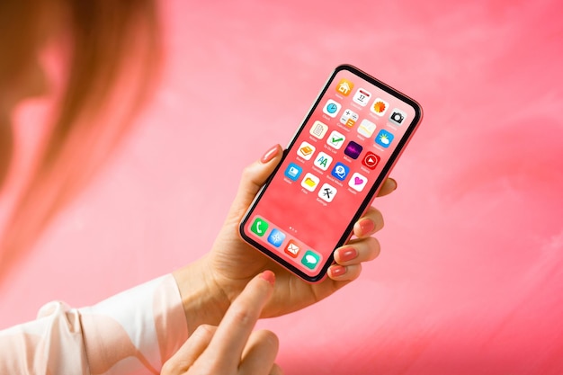 Donna che visualizza la schermata iniziale con le icone delle app del telefono cellulare