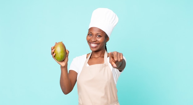 Donna chef adulta afroamericana nera con un mango