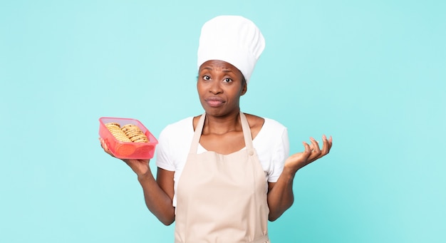 Donna chef adulta afroamericana nera con un tupperware