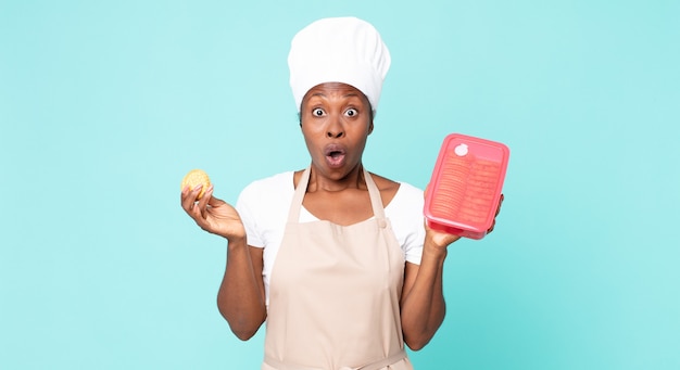 Donna chef adulta afroamericana nera con un tupperware