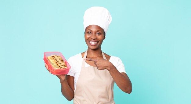 Donna chef adulta afroamericana nera con un tupperware