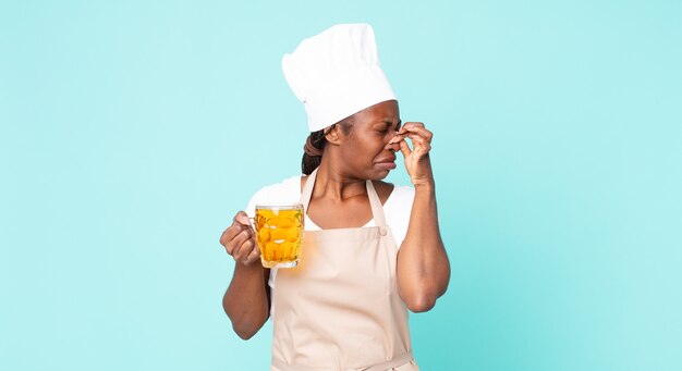 Donna chef adulta afroamericana nera con una pinta di birra