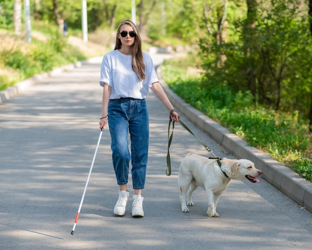 Donna cieca che cammina con un cane guida nel parco