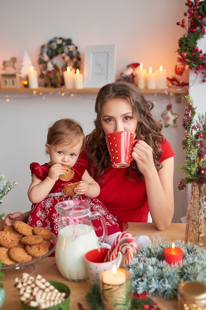 Donna con bambino in cucina decorato per Natale.