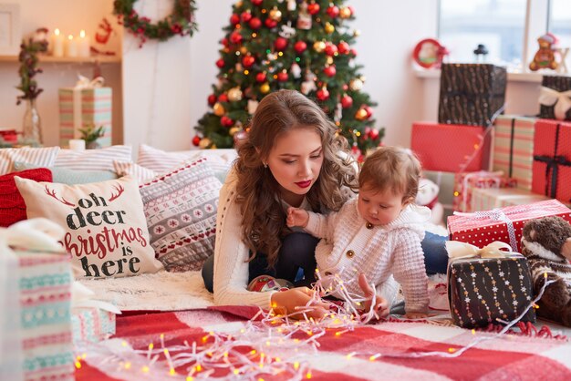 Donna con bambino in cucina decorato per Natale.