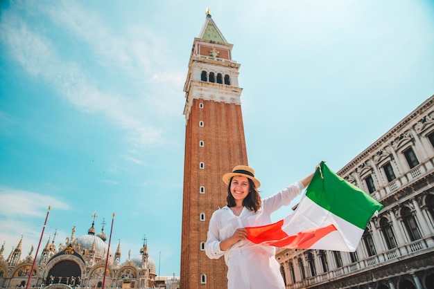 Donna con bandiera italiana nel centro di venezia piazza campanile sullo sfondo ora legale campanile di san marco