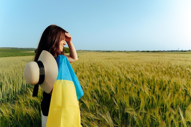 Donna con bandiera ucraina nel campo di grano Ragazzo felice che celebra il giorno dell'indipendenza