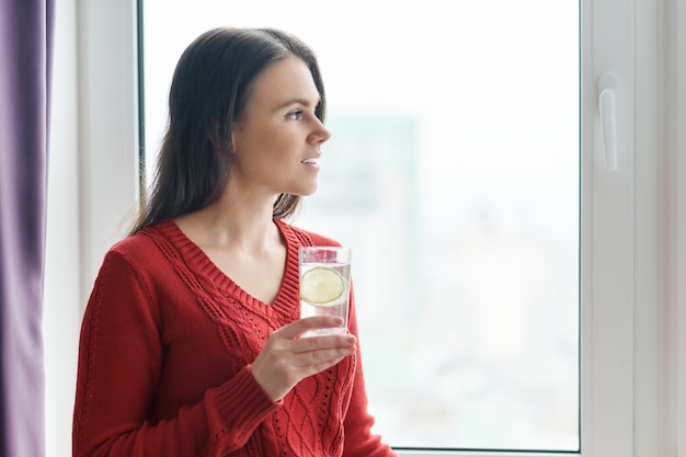 Donna con bicchiere d'acqua con calce