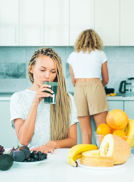 Donna con bicchiere di frullato disintossicante naturale in cucina cibo biologico e vitamina Tendenza dieta vegetariana