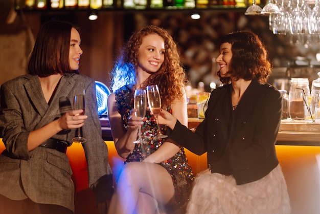 Donna con bicchieri di champagne a una festa. Amici delle donne? Festeggiando insieme le vacanze invernali.