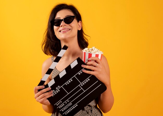 Donna con bicchieri di popcorn e cinema ciak