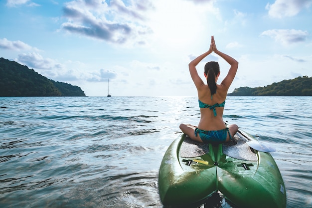 Donna con bikini a paddle board