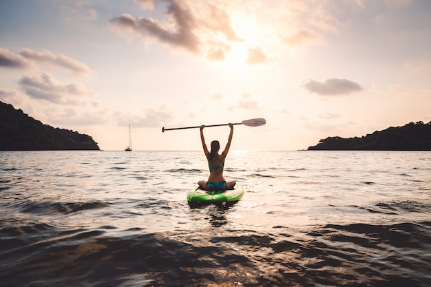 Donna con bikini sul paddle board