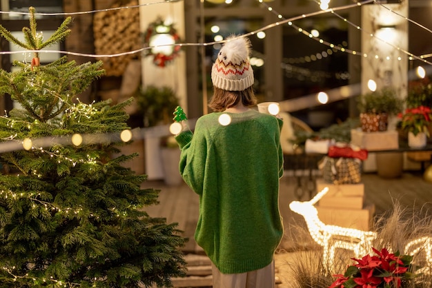 Donna con biscotto e tazza nel cortile decorato di capodanno