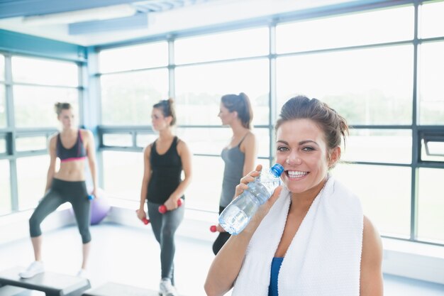 Donna con bottiglia d&#39;acqua in classe di aerobica