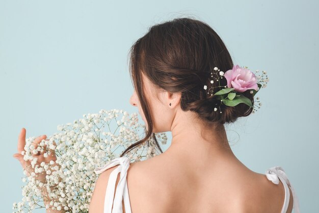 Donna con bouquet di bellissimi fiori su sfondo colorato