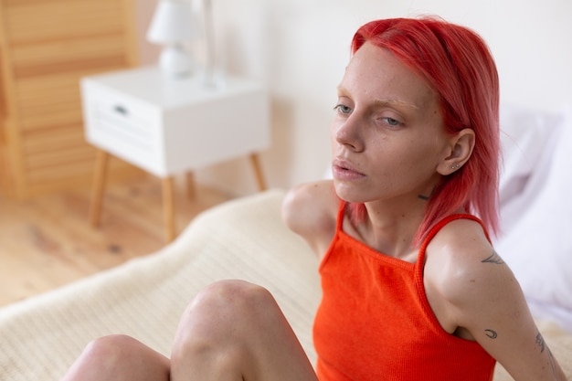 Donna con bulimia. Giovane donna malsana dai capelli rossi con bulimia che si sente stordita e infelice