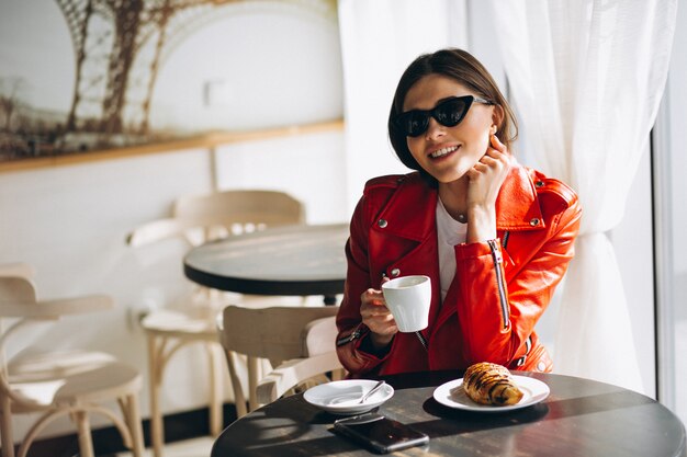 Donna con caffè e croissant