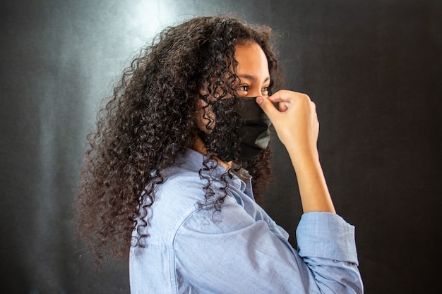 Donna con camicia azzurra e maschera nera