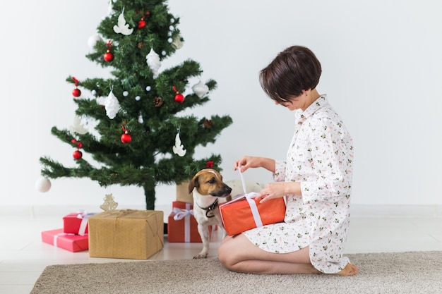 Donna con cane che apre i regali di Natale