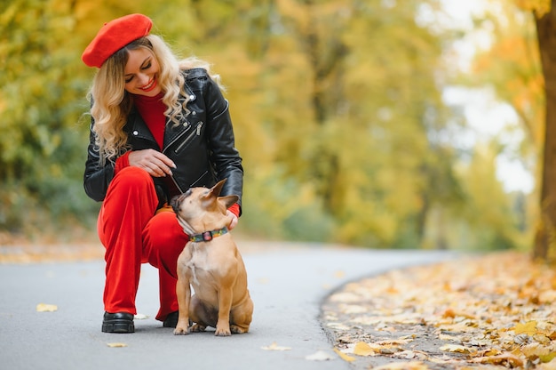 Donna con cane che passeggia nel parco