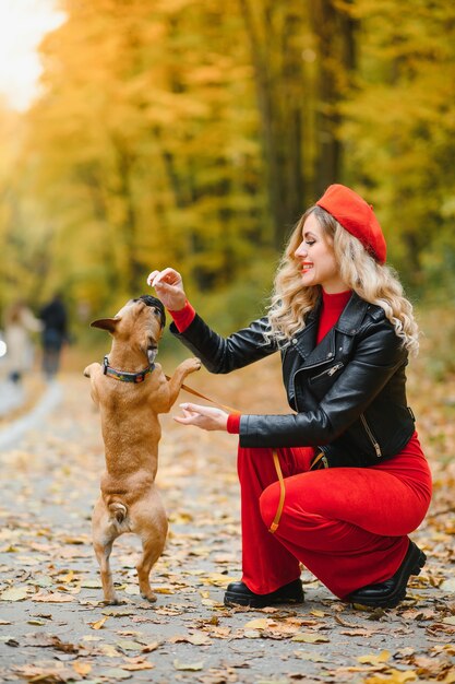 Donna con cane che passeggia nel parco