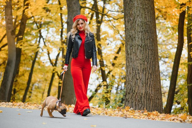 Donna con cane che passeggia nel parco