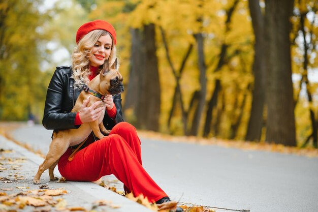 Donna con cane che passeggia nel parco