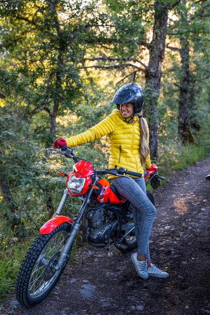 Donna con capelli biondi su una moto