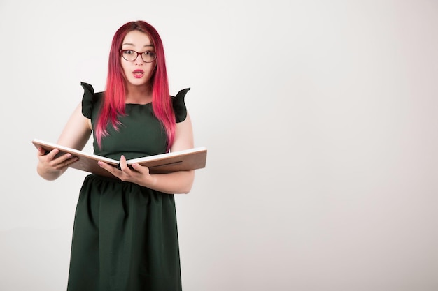 Donna con capelli rosa sul libro bianco della holding