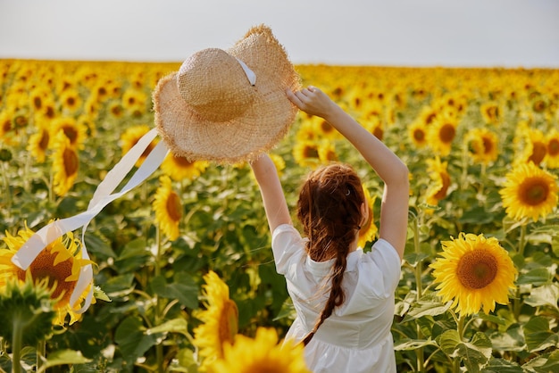 Donna con cappello di paglia nel campo di girasole vista posteriore giornata di sole