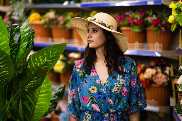 Donna con cappello in un fioraio