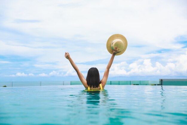 Donna con cappello rilassante in una piscina