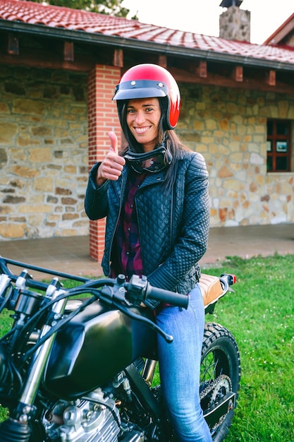 Donna con casco in sella a una moto personalizzata