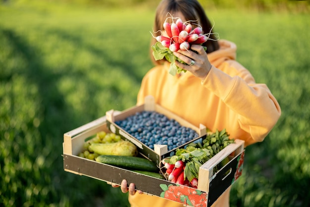 Donna con cibo fresco su terreni agricoli